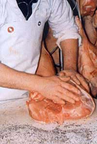 Préparation artisanale d’un morceau de viande chez Le-raygal-charcuterie, atelier traditionnel dans le Tarn