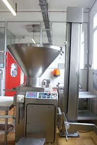 Machine de poussage inox industrielle chez Le-raygal-charcuterie dans un atelier agroalimentaire du Tarn